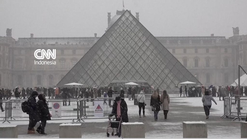 Turis dan Warga Berbahagia Kala Paris Berselimut Salju