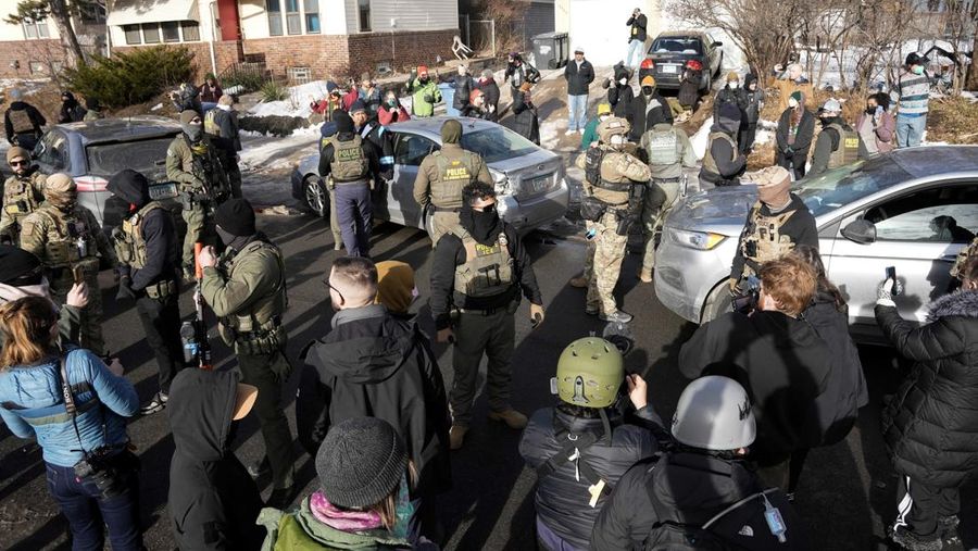 Agen Imigrasi dan Bea Cukai AS (ICE) berdiri di samping mobil warga sipil yang rusak akibat ditabrak oleh ICE, setelah seorang agen ICE menembak mati Renee Nicole Good, di Minneapolis, Minnesota, AS, 12 Januari 2026. (REUTERS/Tim Evans)