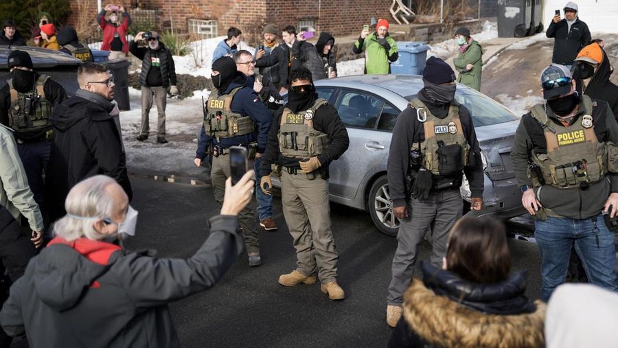 Agen Imigrasi dan Bea Cukai AS (ICE) berdiri di samping mobil warga sipil yang rusak akibat ditabrak oleh ICE, setelah seorang agen ICE menembak mati Renee Nicole Good, di Minneapolis, Minnesota, AS, 12 Januari 2026. (REUTERS/Tim Evans)