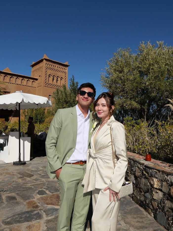 Haviza Devi Anjani dan Harris Vriza bak power couple dengan outfit setelan jas. Harris dengan&nbsp;busana best man, sedangkan Haviza mengimbangi dengan jaket lebih feminin berkat aksen knot&nbsp;di bagian depan serta pilihan rona gading yang cerah/ Foto: instagram.com/havizadevianjani