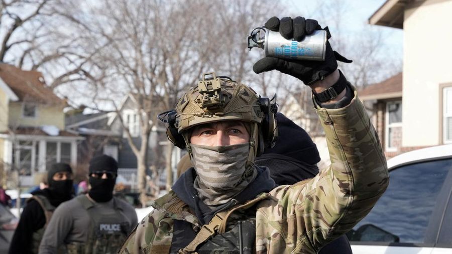 Agen Imigrasi dan Bea Cukai AS (ICE) berdiri di samping mobil warga sipil yang rusak akibat ditabrak oleh ICE, setelah seorang agen ICE menembak mati Renee Nicole Good, di Minneapolis, Minnesota, AS, 12 Januari 2026. (REUTERS/Tim Evans)