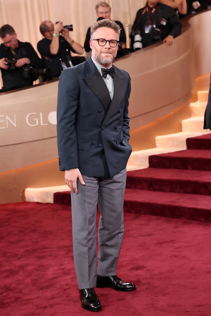 Seth Rogen turut menampilkan gaya formal dan rapinya dengan busana Prada, Beauties. Dark teal mohair double-breasted tuxedo jacket menumpuk jade poplin shirt yang dipadukan dengan celana panjang abu-abu. Dasi kupu-kupu menyempurnakan penampilan maskulinnya/ Foto: Courtesy of Prada/Kevin Mazur/Getty Images/Kevin Mazur