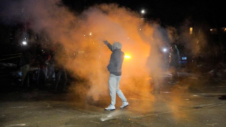 Para pengunjuk rasa berhadapan dan bentrok dengan pihak berwenang di Minneapolis utara dekat lokasi seorang pria ditembak di kaki pada Rabu (14/2/2026). (REUTERS/Ryan Murphy)