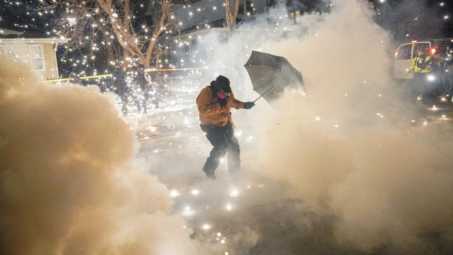 Para pengunjuk rasa berhadapan dan bentrok dengan pihak berwenang di Minneapolis utara dekat lokasi seorang pria ditembak di kaki pada Rabu (14/2/2026). (REUTERS/Ryan Murphy)