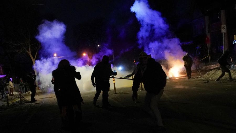 Para pengunjuk rasa berhadapan dan bentrok dengan pihak berwenang di Minneapolis utara dekat lokasi seorang pria ditembak di kaki pada Rabu (14/2/2026). (REUTERS/Ryan Murphy)