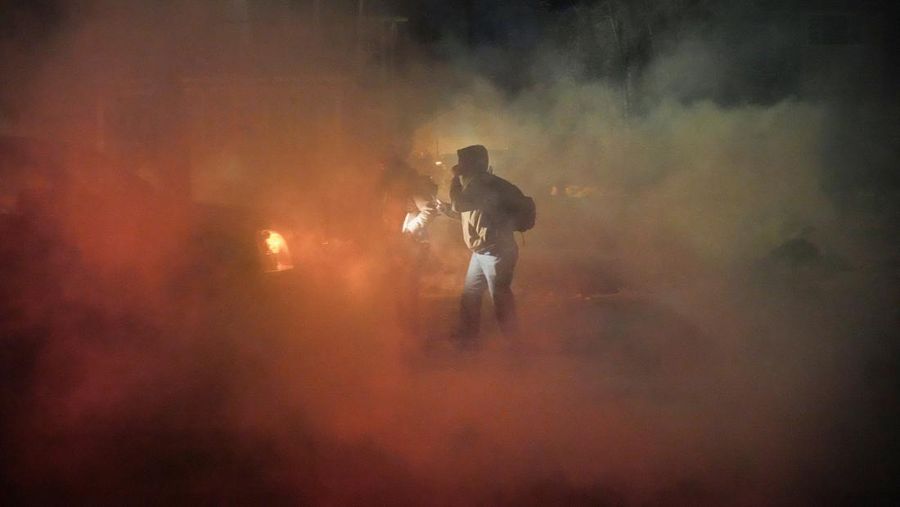 Para pengunjuk rasa berhadapan dan bentrok dengan pihak berwenang di Minneapolis utara dekat lokasi seorang pria ditembak di kaki pada Rabu (14/2/2026). (REUTERS/Ryan Murphy)