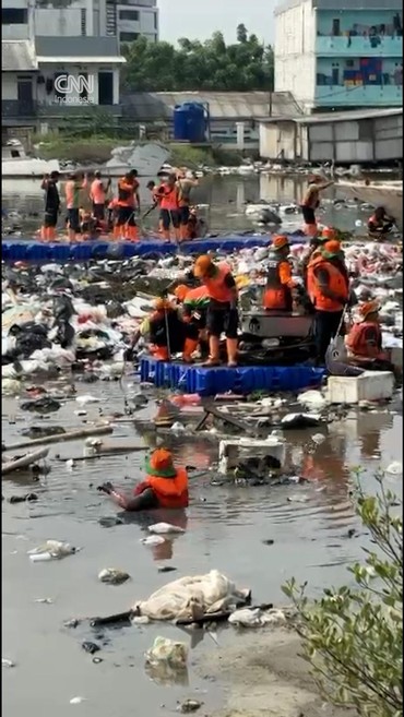 Petugas Bersihkan Sampah Menumpuk di Tanggul Pantai Muara Baru Jakut