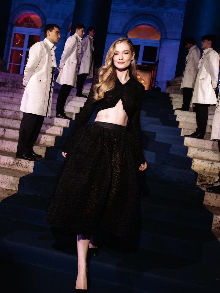 Setelan&nbsp;kreasi Giambattista Valli hitam membalut Hannah Dodd di World Premiere serial Bridgerton. Atasan crop dipadu dengan rok bervolume memberikan impresi ball-gown yang modern/ Foto: instagram.com/bridgertonnetflix