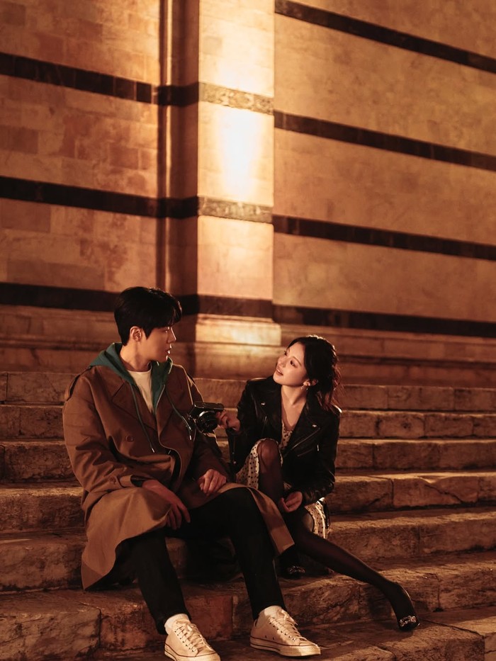 Pada sebuah adegan malam di tangga batu,&nbsp;pemain tokoh&nbsp;Cha Mu-hee&nbsp;tampil dengan&nbsp;biker's jacket&nbsp;hitam&nbsp;yang menumpuk&nbsp;mini dress polkadot.&nbsp;Look yang turut memadukan&nbsp;stocking hitam&nbsp;dan high heels mewah berhias rhinestones ini bawa kesan&nbsp;edgy dan&nbsp;feminin&nbsp;sekaligus/ Foto: instagram.com/netflixid