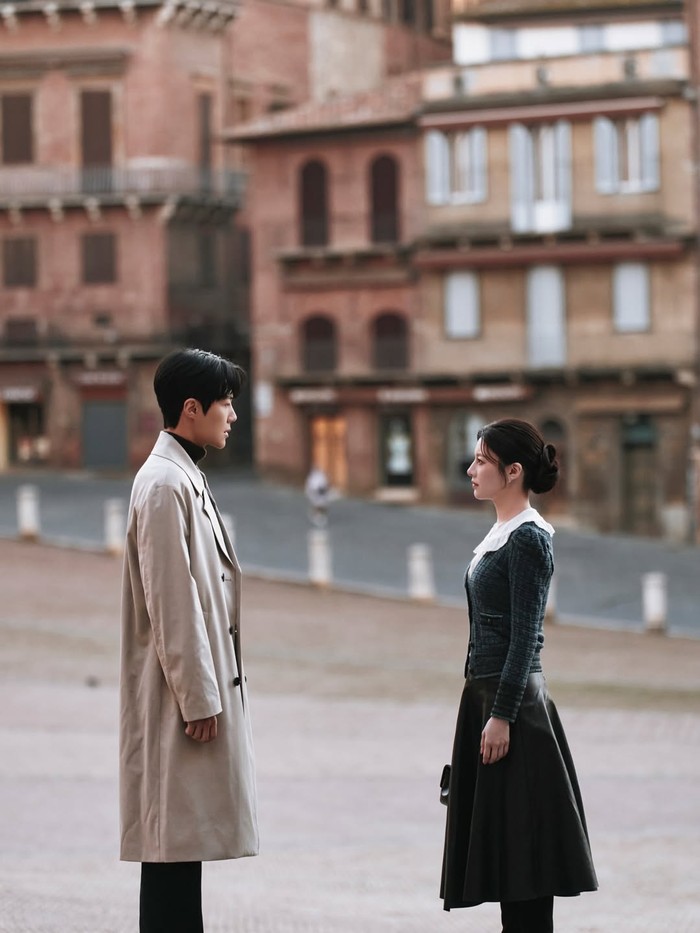 Mengambil latar kota Italia, Go Yoon Jung tampil anggun dengan&nbsp;kemeja&nbsp;putih berkerah peterpan yang manis&nbsp;dan blazer tweed gelap. Rok midi plisket hitam dipadu stocking senada menambah kesan elegan dan rapi pada penampilannya./ Foto: instagram.com/netflixid