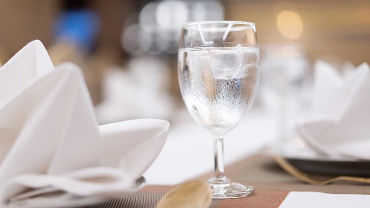 Ice in a clear glass on the dining table bokeh light background&period;
