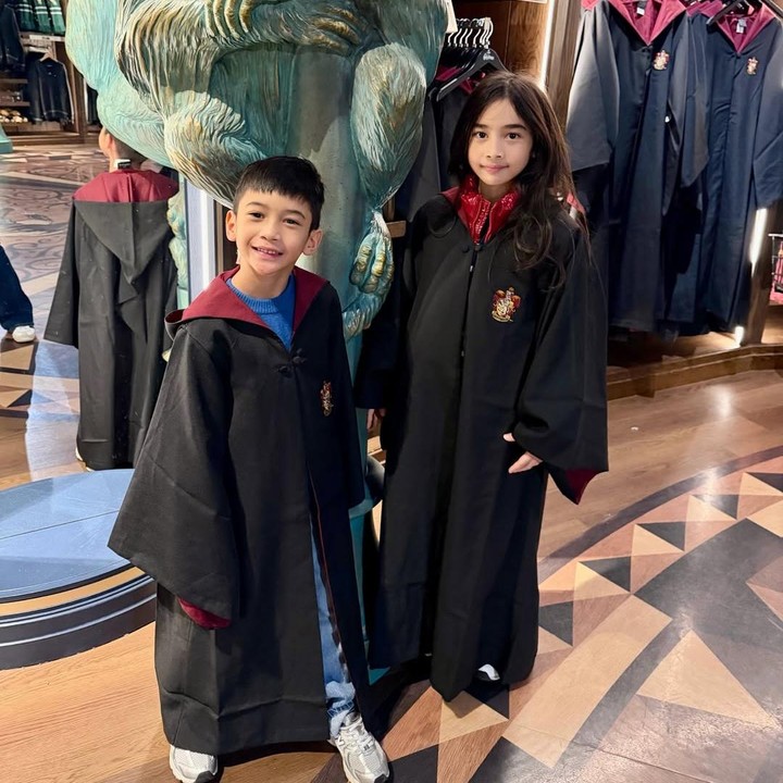 <p>Tak hanya itu, anak-anaknya pun terlihat mencoba mengenakan jubah sekolah Hogwarts seperti karakter Harry Potter. Keduanya terlihat menggemaskan, bukan, Bunda?&nbsp;(Foto: Instagram @nsyakieb85)</p>