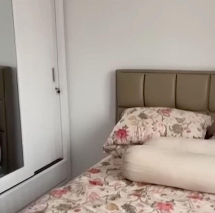 <p>Begitu naik ke lantai dua, kita akan langsung melihat kamar pribadi Nunung yang terlihat nyaman.&nbsp;Tempat tidurnya tampak luas dengan seprei bermotif bunga. Pada bagian kanan kasur, terlihat lemari dua pintu yang tidak terlalu besar. Nah, karena lemari ini masih baru, isiannya tampak kosong, Bunda. Rupanya, bajunya masih ia simpan di kamar sebelah. "Bajunya ada masih di kamar sebelah. Kamar sebelah itu sebenarnya buat kamar <em>wardrobe</em>, tapi aku kasih kasur siapa tau ada tamu gitu," kata Nunung. (Foto: Youtube @TRANS7Official)</p>