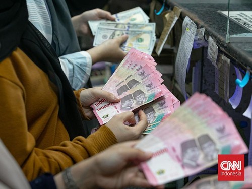 Warga menukarkan uang di Money Changer, Kawasan Kuningan, Jakarta, Selasa (20/1/2026). (CNN Indonesia/Adi Ibrahim)