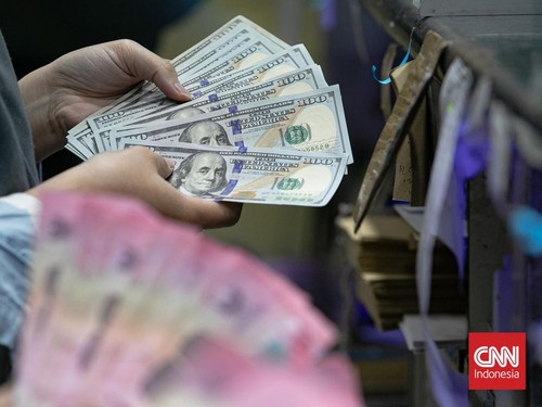 Warga menukarkan uang di Money Changer, Kawasan Kuningan, Jakarta, Selasa (20/1/2026). (CNN Indonesia/Adi Ibrahim)