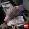 Warga menukarkan uang di Money Changer, Kawasan Kuningan, Jakarta, Selasa (20/1/2026). (CNN Indonesia/Adi Ibrahim)