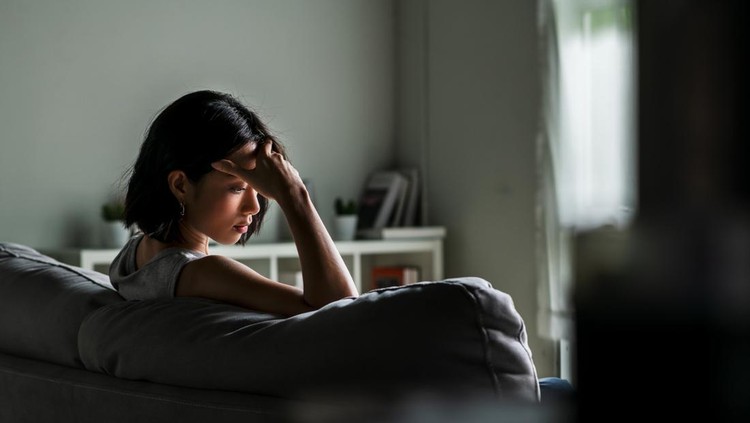 Young Asian woman sitting on sofa at home feeling sad tired and worried suffering depression in mental health&period;
