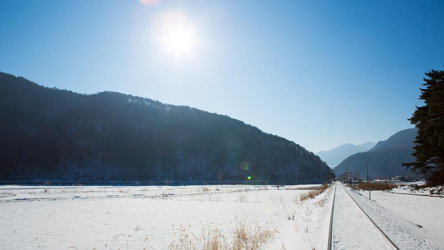 Railway in winter with sun