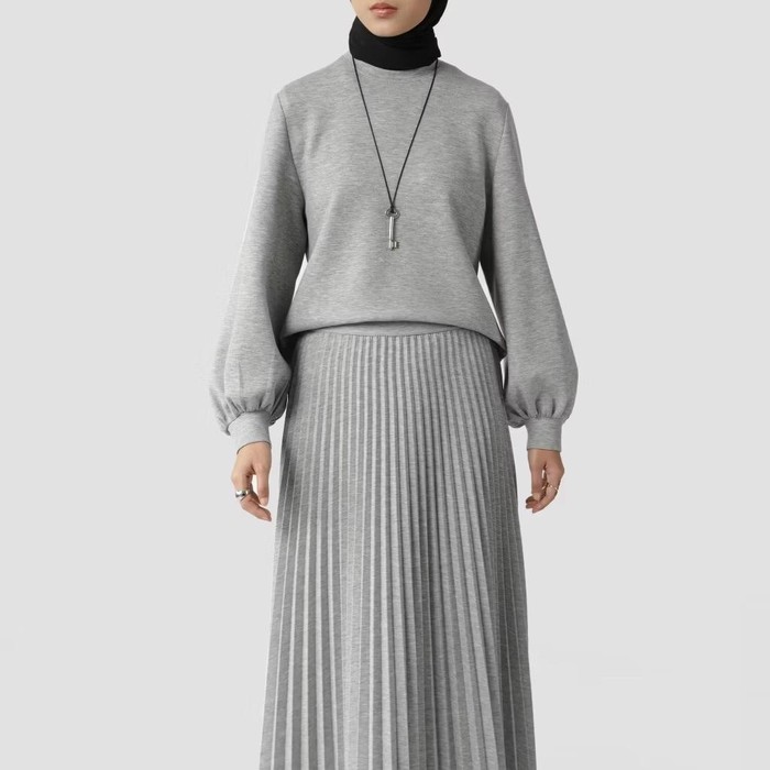Sweater ini memiliki fitted silhouette, puffed sleeves, dan gathered cuffs. Panjang sweater jatuh di atas pinggul, dengan lengkungan halus di bagian hemline.
