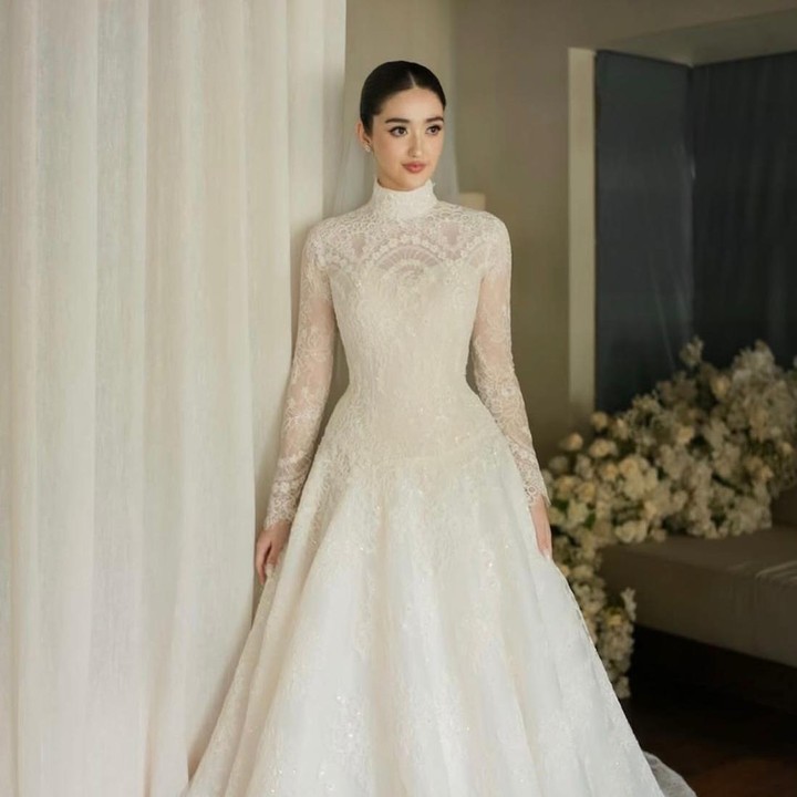 <p>"Siluetnya kuat dan berstruktur, diperhalus oleh renda halus yang membuatnya tetap intim dan emosional. Garis leher yang tinggi menambah keanggunan, sementara bagian atas yang pas dan rok yang mengalir menciptakan drama yang tenang dan tanpa usaha. Gaun ini tidak meminta perhatian, melainkan menuntutnya. Abadi, tenang, dan tak diragukan lagi elegan," tulis akun Instagram <em>@hiantjen</em>. (Foto: Instagram @hiantjen)</p>