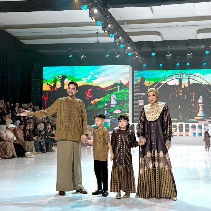 <p>Aryani Fitriana dan Donny Michael tampil bersama kedua anak mereka, Alem Isco dan Aleia Astrid saat melangkah di <em>runway</em> membawakan koleksi busana Lebaran dari Shireen&ndash;Zaskia Sungkar. Keluarga ini dipercaya memperagakan koleksi Imperial Reverie karya Zaskia Sungkar. Aryani dan Donny tampil kompak mengenakan busana Muslim dengan&nbsp;<em>pattern</em> bernuansa <em>bold</em> dan sentuhan <em>edgy</em>. Keserasian juga tampak pada penampilan anak-anak mereka. Alem tampil senada dengan sang Ayah, sementara Aleia tampak manis mengenakan <em>dress</em> cokelat yang bermotif klasik. (Foto: HaiBunda/Nadhifa Fitrina)</p>