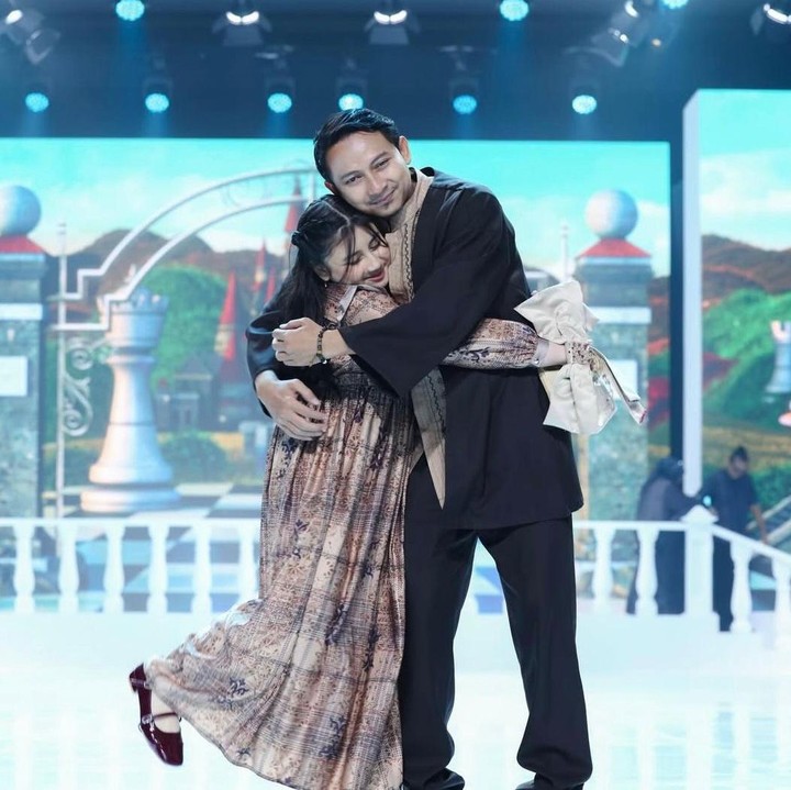 <p>Komedian Aden Bajaj ikut meramaikan Ramadhan Show Shireen-Zaskia Sungkar bersama putrinya, Shaka. Saat melangkah di atas panggung, Ayah dan anak ini tampak kompak dalam balutan busana Lebaran. Aden terlihat memakai&nbsp;baju koko hitam dengan detail <em>layer</em> bermotif cokelat. Sementara itu, Shakara tampil manis mengenakan <em>dress</em> dari koleksi Imperial Reverie karya Zaskia Sungkar. Momen haru pun tercipta ketika keduanya saling berpelukan usai berpose di atas <em>runway</em>. (Foto: Instagram @shireensungkar)</p>