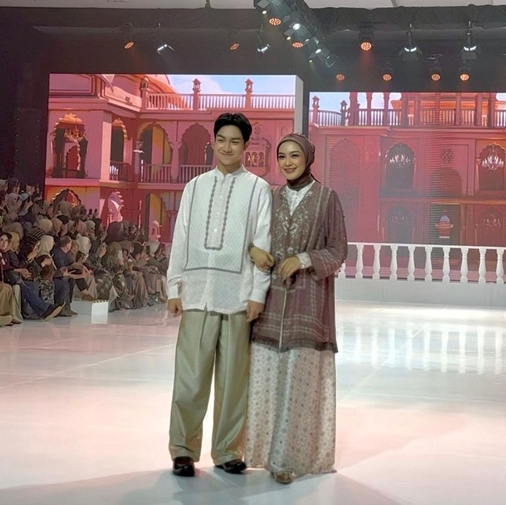 <p>Istri dari mendiang Gary Iskak, Richa Novisha, turut tampil bersama putranya, Adilla Rafisya, sebagai <em>muse</em> dalam koleksi busana Lebaran Shireen&ndash;Zaskia Sungkar. Di atas <em>runway</em>, Richa terlihat anggun memakai&nbsp;<em>dress</em> berpadu <em>outer</em> dengan sentuhan <em>pattern</em> yang cantik. Sementara itu, Adilla tampil mengenakan baju koko putih dengan motif simpel di bagian depan. Bunda dua anak mengungkapkan bahwa ini pengalaman pertama sang putra untuk tampil menjadi model <em>catwalk</em>. "Terima kasih <em>@shireensungkar</em> sayang! Ini pertama kalinya kakak <em>@ravisha_adila019</em> <em>runway</em>. Dia senang sekali! Terima kasih sudah mengundang kami, sayang," tulis Richa lewat Instagram Stories-nya. (Foto: HaiBunda/Nadhifa Fitrina)</p>