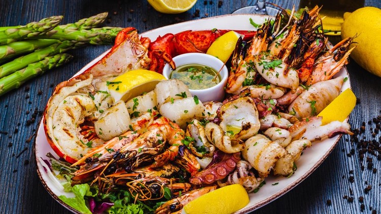 Seafood platter&period; Grilled lobster&comma; shrimps&comma; scallops&comma; langoustines&comma; octopus&comma; squid on white plate&period;