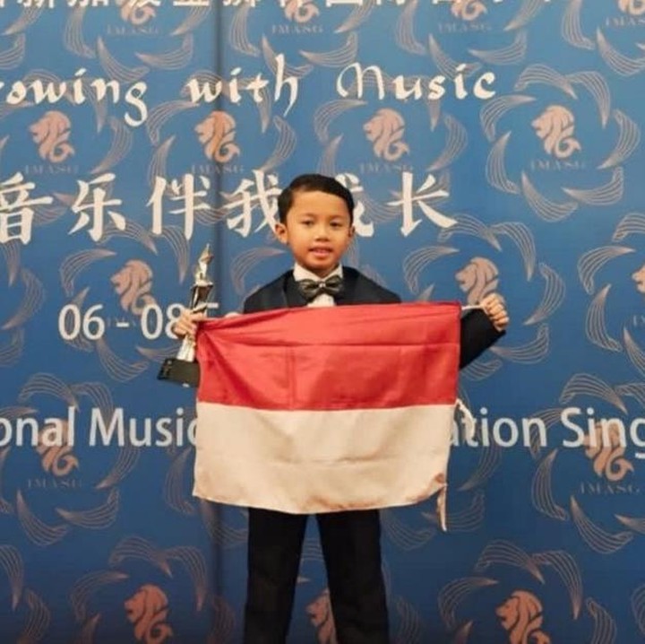 <p>Lewat akun Instagram-nya, anak asal Bojonegoro ini juga membagikan pengalaman mengikuti kompetisi piano internasional tersebut. "Halo teman-teman. Aku mau cerita pengalamanku ikut kompetisi piano di Singapura kemarin. Aku baru saja selesai tampil di 7th Singapore Golden Lion Awards 2026. Perjalananku ini dimulai dari Indonesia, waktu aku ikut babak nasional di RIPC (Rhapsody Indonesia Piano Competition) 2025. Senang sekali waktu itu aku bisa meraih Juara 1 diantara ratusan peserta, dan itu yang membuatku makin semangat untuk latihan setiap hari supaya bisa mewakili Indonesia di level internasional," tuturnya, dikutip dari akun Instagram <em>@paramahansa.id</em>. (Foto: Instagram @paramahansa.id)</p>