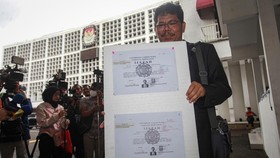 Pengamat Kebijakan Publik Bonatua Silalahi menunjukan salinan asli ijazah Presiden ke-7 Joko Widodo di depan kantor KPU RI, Jakarta, Senin (9/2/2026).