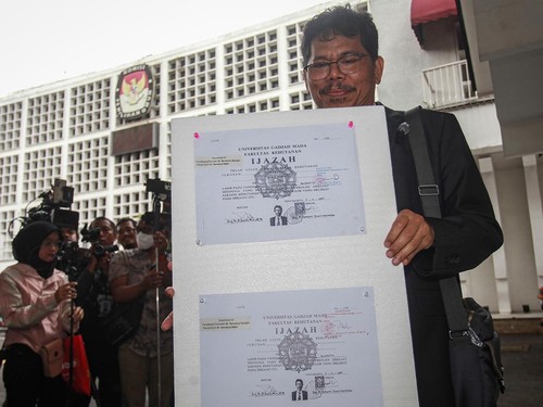Pengamat Kebijakan Publik Bonatua Silalahi menunjukan salinan asli ijazah Presiden ke-7 Joko Widodo di depan kantor KPU RI, Jakarta, Senin (9/2/2026).