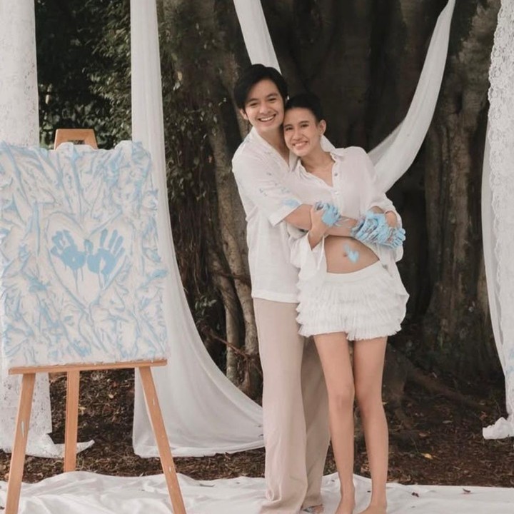 <p>Meski hanya mengusung konsep sederhana, momen <em>gender reveal</em> Shenina dan Angga tetap tampak <em>aesthetic</em>, Bunda. Keduanya tampil simpel dan rapi. Shenina mengenakan kemeja lengan panjang yang menonjolkan <em>baby bump</em>-nya. Sementara Angga tampil serasi dengan kemeja putih lengan pendek yang kasual. (Foto: Instagram @angga / @sheninacinnamon)</p>