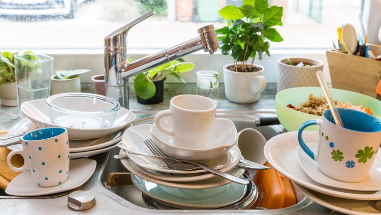 Messy kitchen counter with pile of dirty dishes in sink - Compulsive Hoarding Syndrome&period;