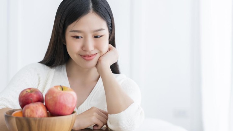 Ilustrasi perempuan makan apel