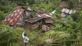 Warga melihat rumah yang ambruk terdampak bencana tanah bergerak di Desa Tandihat, Angkola Selatan, Tapanuli Selatan, Sumatera Utara, Kamis (19/2/2026). Pemerintah Kabupaten Tapanuli Selatan akan merelokasi 186 KK penyintas bencana tanah bergerak di