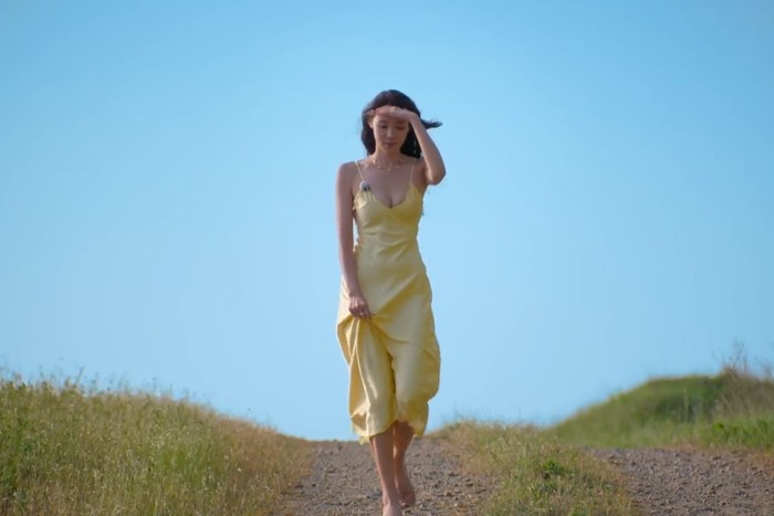 Choi Mina Sue tampil minimalis namun memikat dengan satin dress kuning. Siluet sederhana memberi kesan elegan dan modern./ Foto: netflix.com