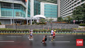 FOTO: Di Tengah Hujan dan Sepi Pelari, Fotografer CFD Tetap Menanti