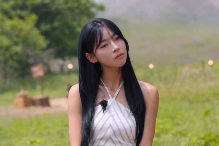 Ivory halter dress bergaya feminine elegant dengan open-back detail dan garis hijau lembut. Flowing, classy, dan resort glam./ Foto: netflix.com