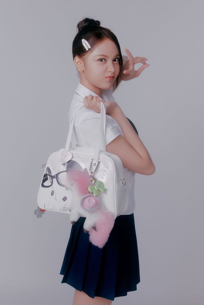 Di foto konsep 'STYLE' lainnya, Carmen tampil melokal ala anak SMA di indonesia yang khas dengan tatanan rambut diikat dan hiasan jepit sebagai pemanis penampilan serta membawa tas berhiaskan gantungan lucu ./ Foto: instagram.com/hearts2hearts