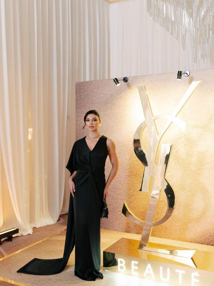 Gaun hitam Jihane Almira membawa drama. Lengan asimetris bergaya cape menjuntai menyapu lantai, sedangkan potongan sleeveless pada sisi lainnya. Potongan V-neckline yang dalam berpadu apik dengan pendant necklace. Tatanan rambut updo menambah keanggunannya/ Foto: Dok. YSL
