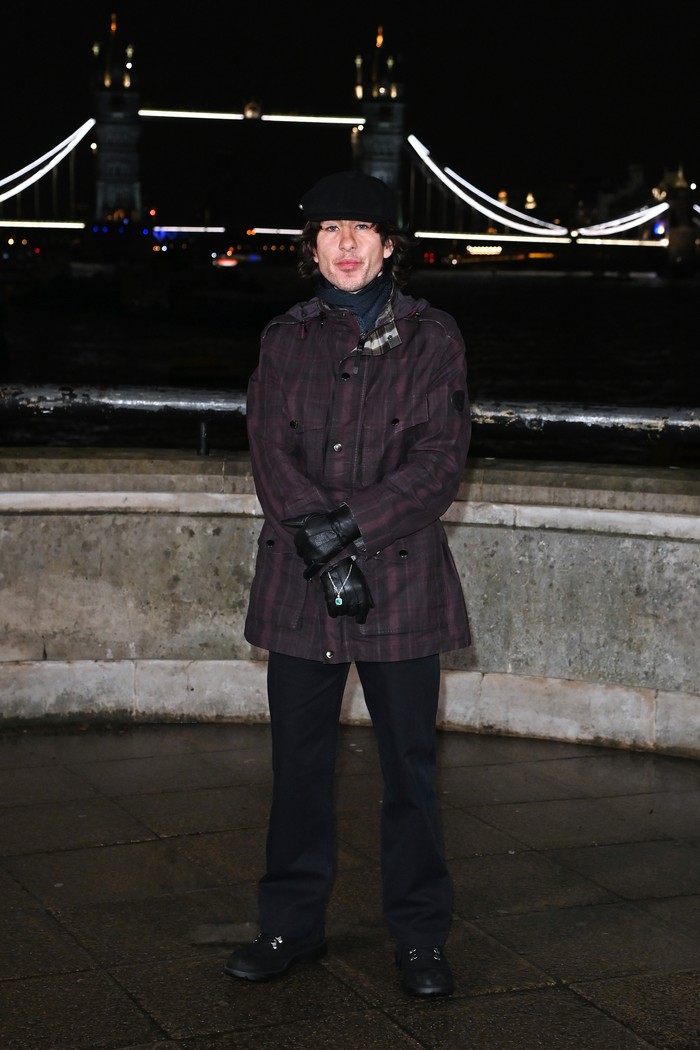 Barry Keoghan turut dijumpai di peragaan busana yang berlangsung di Old Billingsgate, Beauties! Di antara fashion items warna hitam yang dikenakannya seperti celana panjang, sneakers,&nbsp;dan beanie, jaket parka motif plaid rona wine jadi aksen yang membuat gayanya menarik/ Foto: Courtesy of Burberry/Dave Benett/Dave Benett