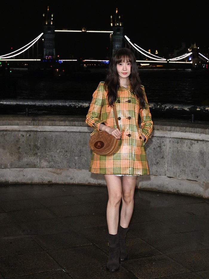 Double breasted coat tartan dalam warna hijau dan oranye jadi daya tarik penampilan Lim Yoona. Coat yang dikenakan layaknya dress itu dipadu dengan Burberry Tavistock Crossbody Bag dan ankle boots/ Foto: Courtesy of Burberry/Alan Chapman/Dave Benett/Gett.../Dave Benett