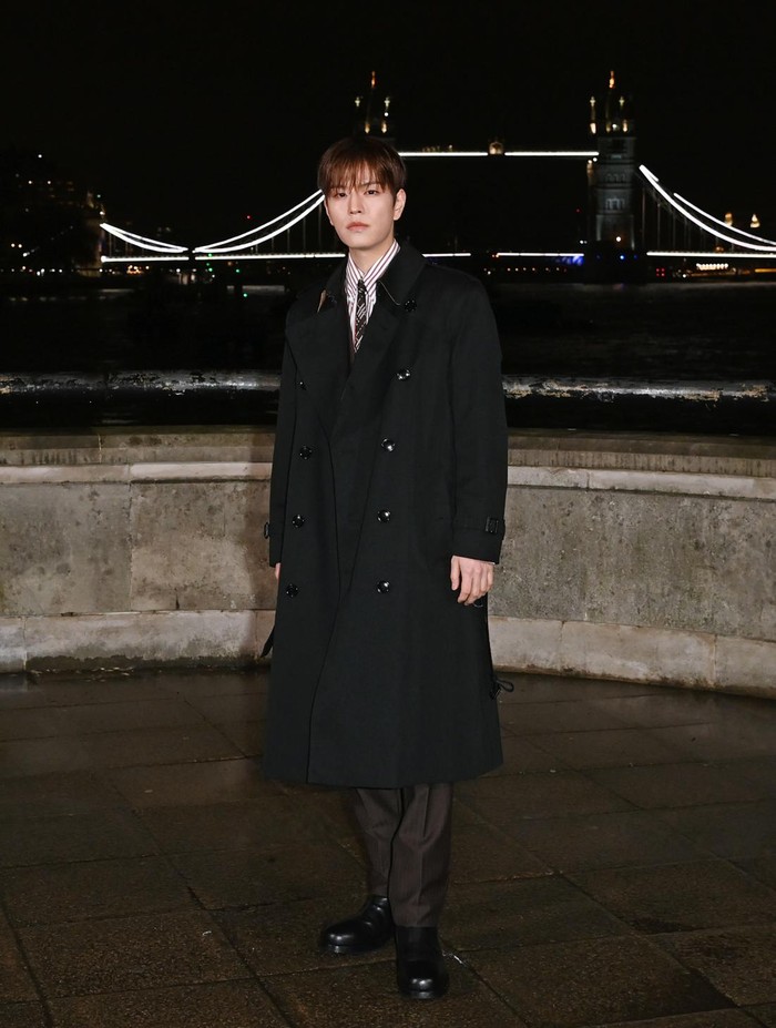 Anggota Stray Kids, Seungmin, hadir sebagai brand ambassador Burberry, Beauties. Rapi dan formal, mantel hitam polos diberi sentuhan unik lewat perpaduan motif garis kemeja dan motif dasi hitam yang lebih artsy. Gaya musim dinginnya turut dilengkapi tailored pants coklat dan ankle boots hitam / Foto: Courtesy of Burberry/Alan Chapman/Dave Benett/Gett.../Dave Benett