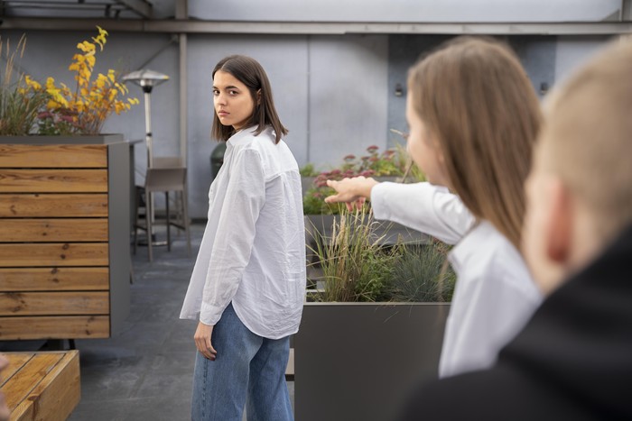 Tanda sikap orang yang diam-diam senang melihatmu kesulitan adalah mereka mungkin hanya menatapmu dengan senyum penuh arti alih-alih menawarkan bantuan saat kamu kesulitan.
