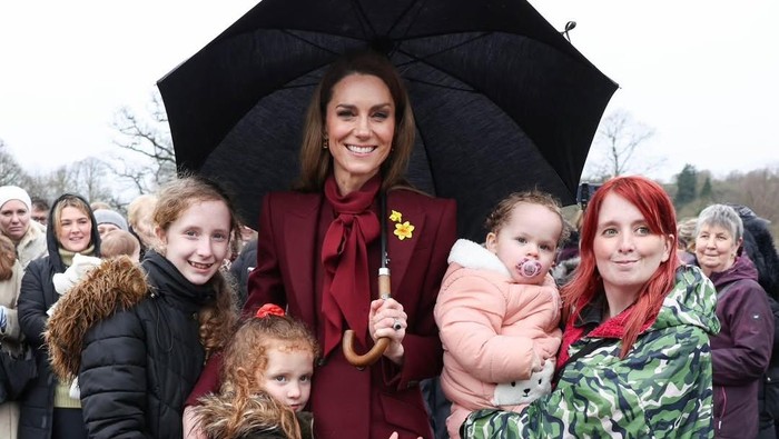 Putri Kate bertemu dengan komunitas lokal saat mengunjungi Newton, Wales. Ia mengenakan outfit serba burgundy.