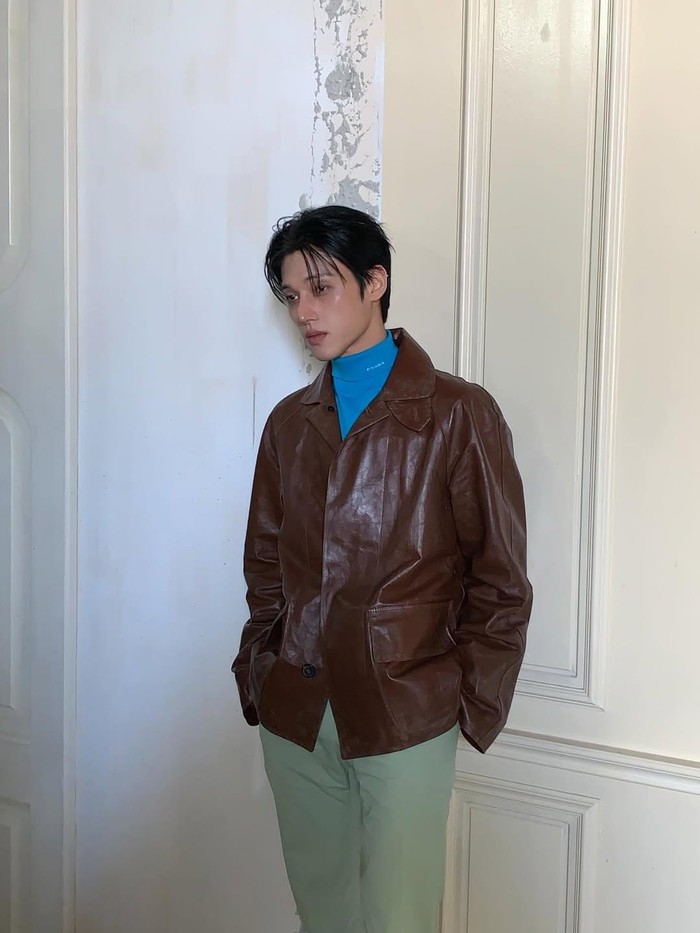 Pada kesempatan kali ini, Wooyoung tampil menawan dan maskulin dalam perpaduan leather jacket berwarna cokelat, turtle neck berwarna biru, serta celana bernuansa beige./ Foto: instagram.com/wooyounggg__
