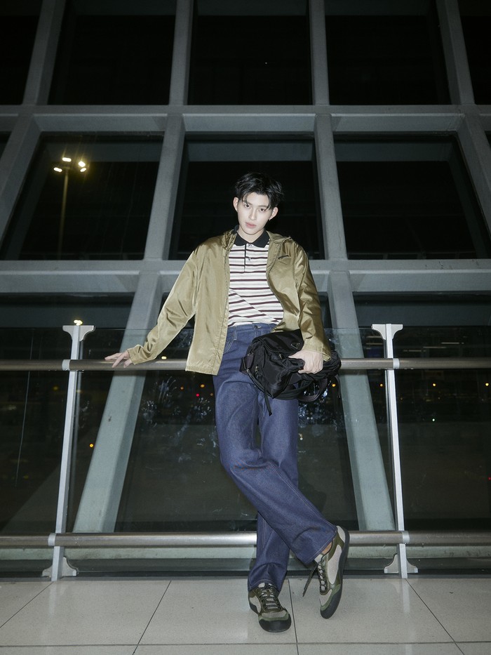 Gaya dengan vibe kasual retro dikenakan Pond Naravit. Polo shirt bergaris dikenakannya bersama&nbsp;parachute jacket dan celana jeans./ Foto: Dok. Prada