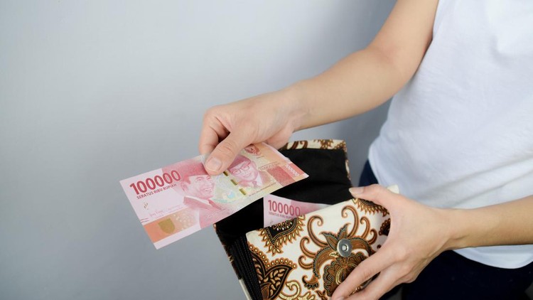 Woman take out from her wallet and Showing 100&period;000 Indonesian Rupiah Money