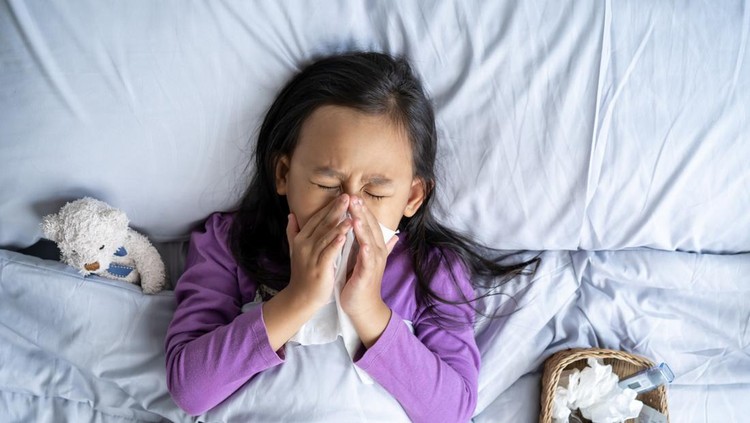 Top view Asian child girl sick with sneezing on the nose and cold cough on tissue paper because weak&comma; Sick child with fever and illness in bed&period;