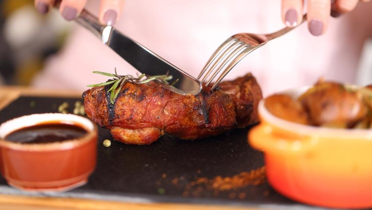 woman eating steak in a restaurant